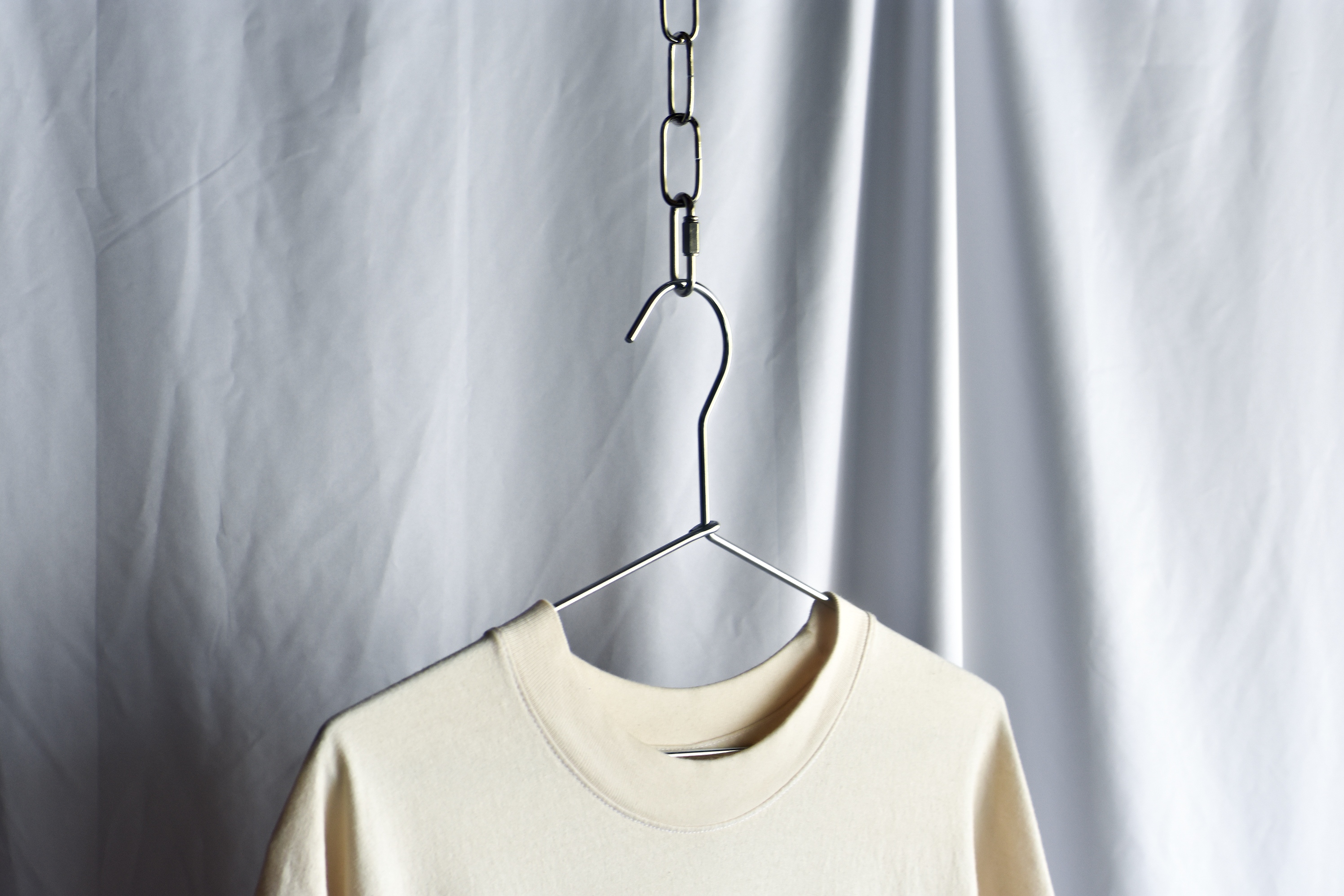 T-shirt Hanging on coat hanger from metal chain.